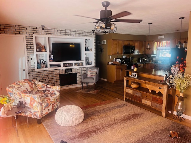 living room with visible vents, ceiling fan, and wood finished floors