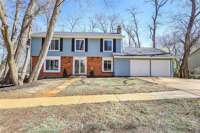 colonial house with concrete driveway, an attached garage, brick siding, and a chimney