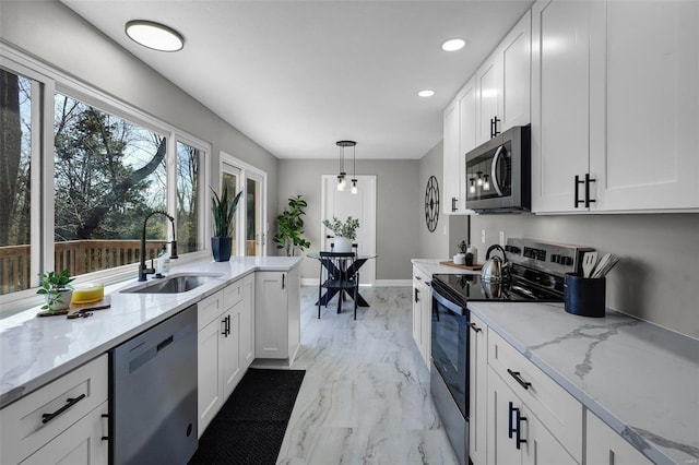 kitchen featuring a sink, light stone counters, white cabinetry, and stainless steel appliances