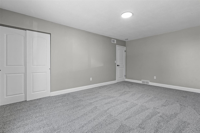 unfurnished bedroom with a closet, visible vents, and carpet flooring