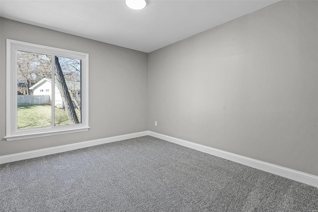 unfurnished room featuring baseboards and carpet