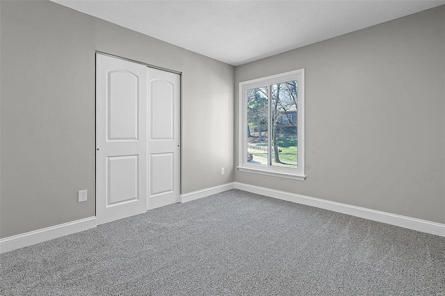 unfurnished bedroom with a closet, baseboards, and carpet floors