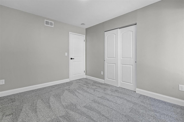 unfurnished bedroom with carpet, visible vents, a closet, and baseboards