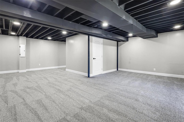 finished basement featuring electric panel, baseboards, and carpet