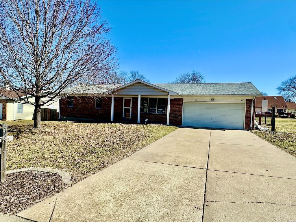 single story home with a garage, brick siding, and driveway