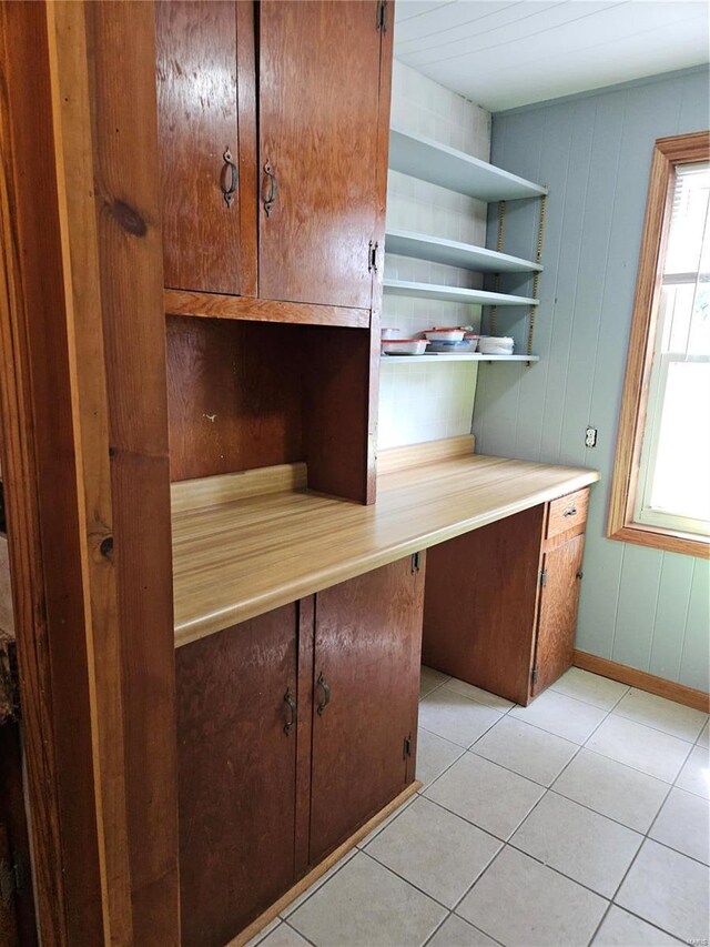 kitchen with open shelves, baseboards, light tile patterned flooring, and light countertops