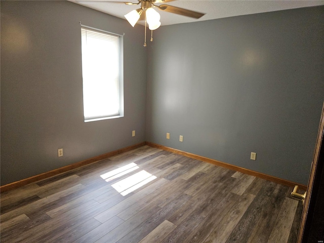 empty room featuring ceiling fan, baseboards, and wood finished floors