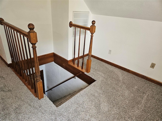 staircase with baseboards, carpet floors, and vaulted ceiling