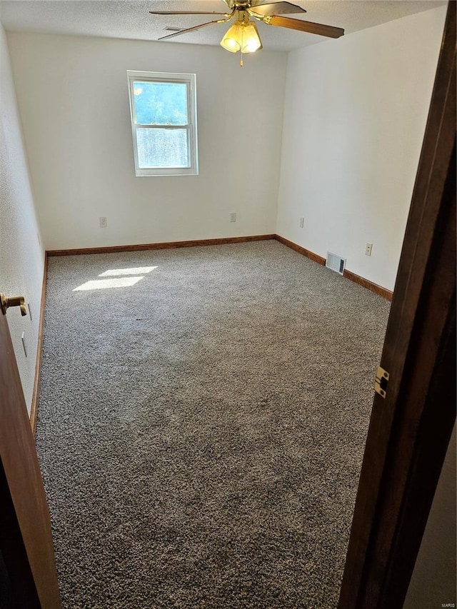 spare room featuring visible vents, baseboards, carpet, a textured ceiling, and a ceiling fan