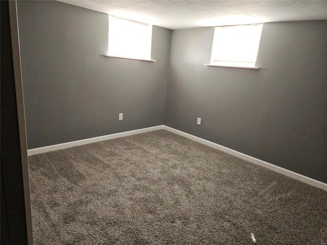 below grade area featuring carpet flooring, a healthy amount of sunlight, and baseboards