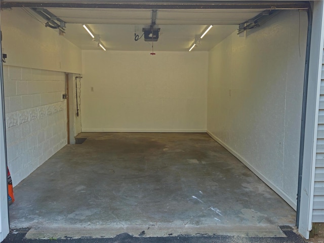 garage with concrete block wall and a garage door opener