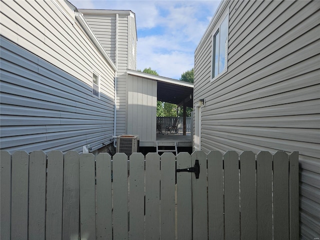 view of home's exterior with central air condition unit and fence