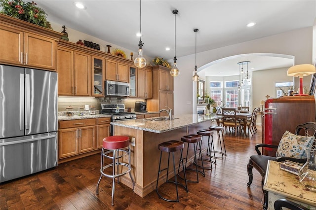 kitchen with decorative backsplash, brown cabinets, appliances with stainless steel finishes, and a sink