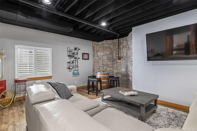 living area with baseboards and wood finished floors