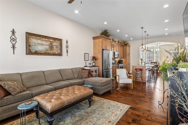 living area with dark wood finished floors, recessed lighting, and ceiling fan with notable chandelier