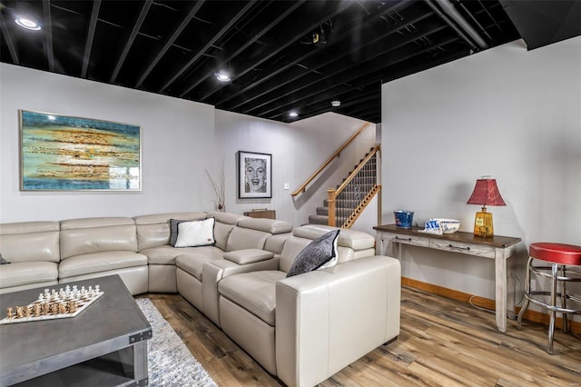 living area with stairway, baseboards, and wood finished floors