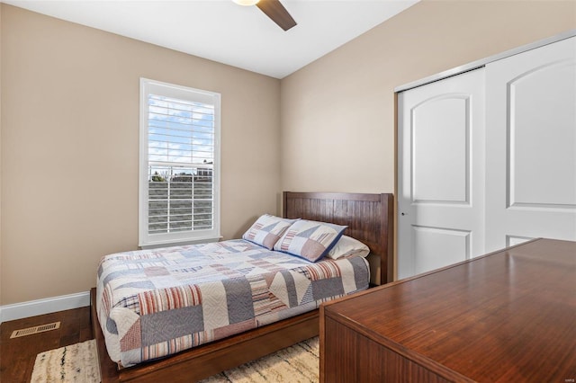 bedroom with wood finished floors, baseboards, visible vents, ceiling fan, and a closet