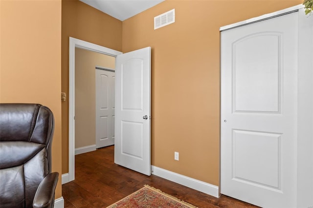 unfurnished room featuring dark wood finished floors, baseboards, and visible vents