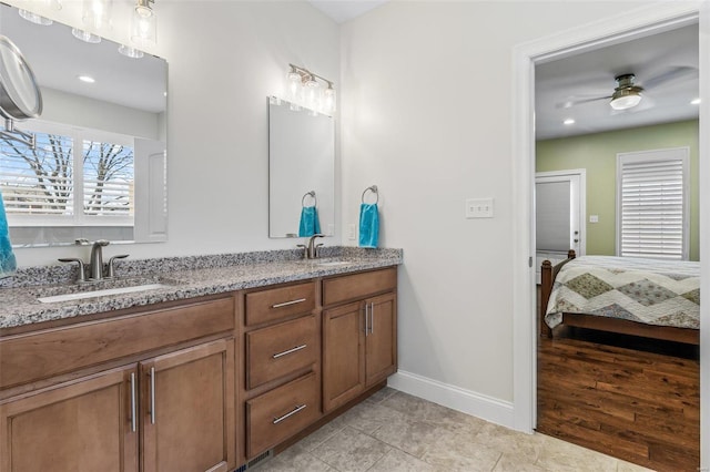 ensuite bathroom with double vanity, ensuite bath, ceiling fan, and a sink