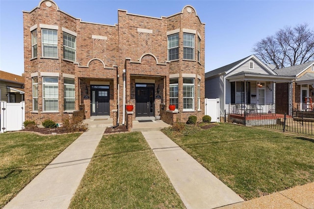 view of front of home featuring fence, brick siding, a front yard, and a gate