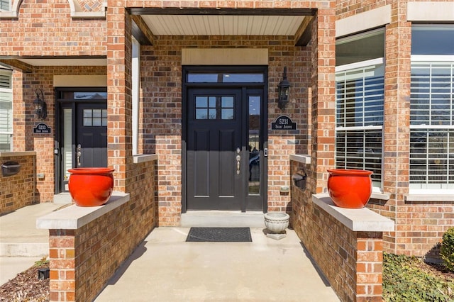 doorway to property featuring brick siding