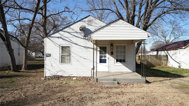 view of front of property featuring a patio area, a front yard, and fence