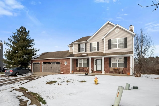 traditional-style home featuring brick siding, driveway, a chimney, and a garage