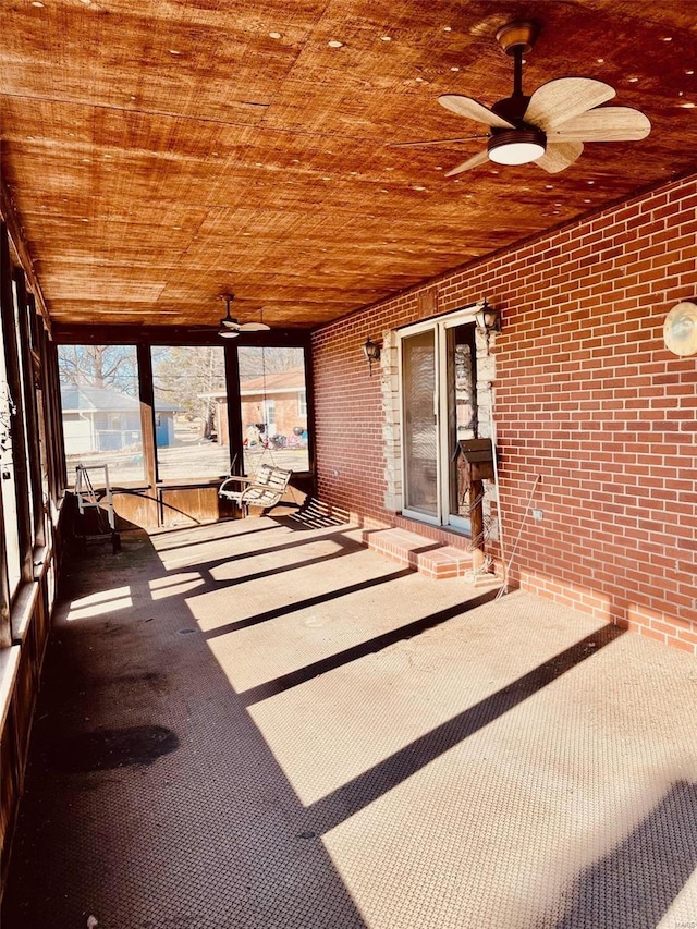 unfurnished sunroom with a wealth of natural light, wood ceiling, and ceiling fan