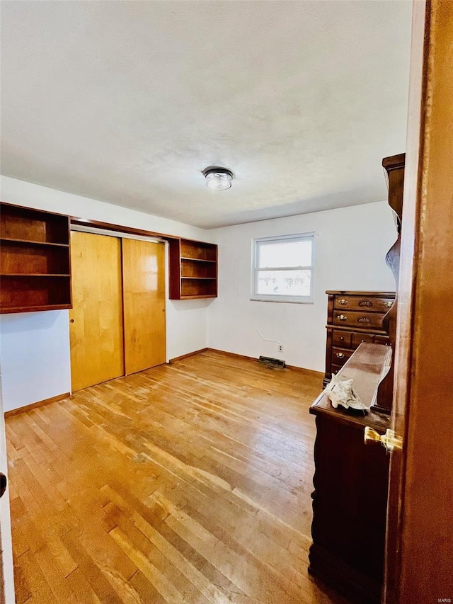 unfurnished bedroom with light wood-type flooring and baseboards