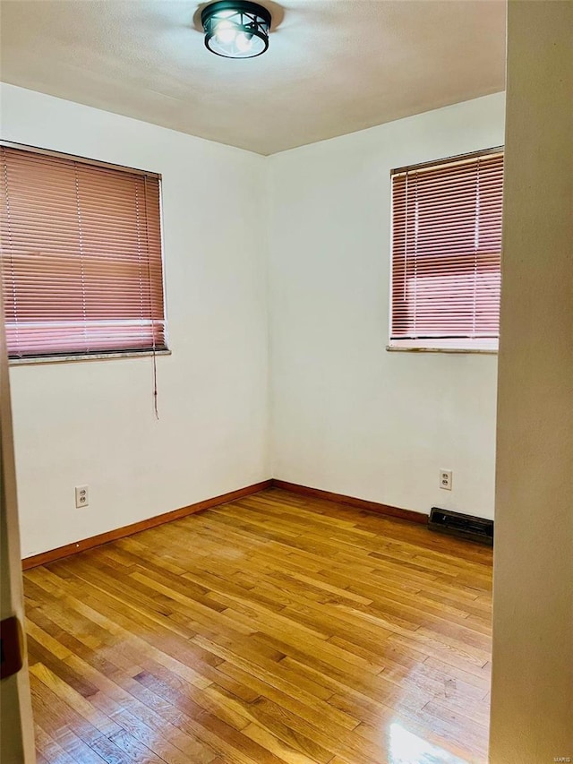 unfurnished room featuring hardwood / wood-style flooring and baseboards