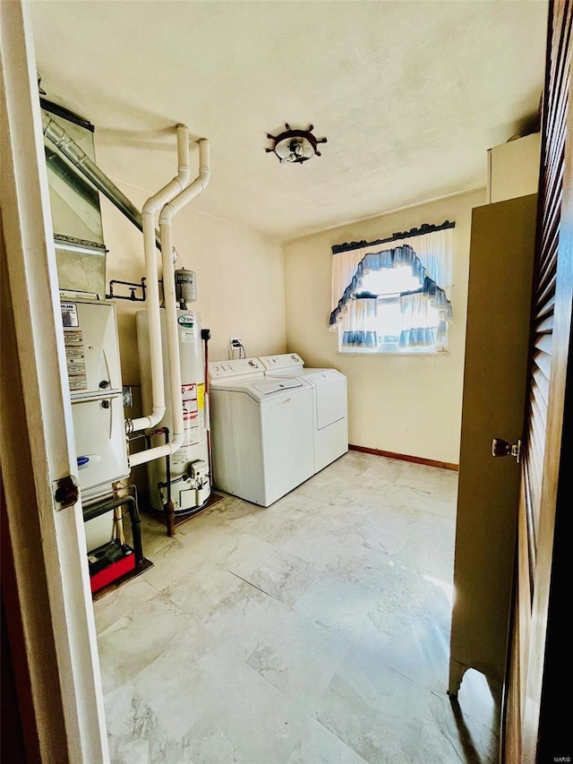 laundry room featuring marble finish floor, washing machine and dryer, water heater, baseboards, and laundry area