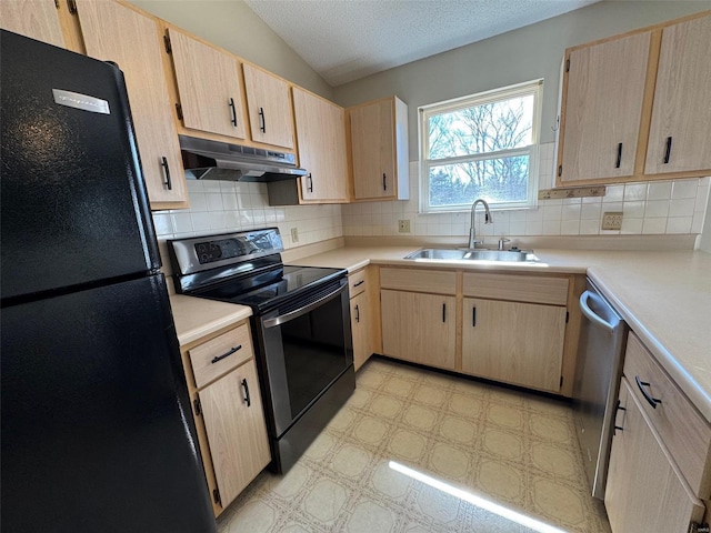 kitchen with a sink, light brown cabinetry, under cabinet range hood, and stainless steel appliances