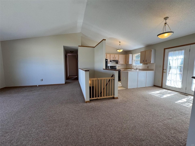 kitchen featuring a sink, stainless steel electric range oven, lofted ceiling, and light colored carpet