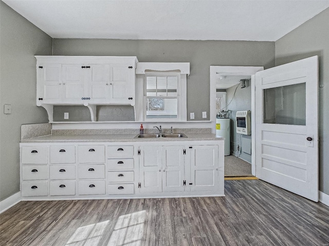 kitchen with dark wood finished floors, white cabinetry, electric water heater, and a sink