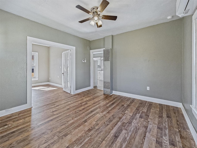 spare room featuring wood finished floors, baseboards, and ceiling fan