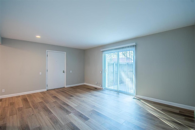 empty room with recessed lighting, baseboards, and wood finished floors