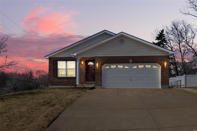 ranch-style house featuring a garage, brick siding, driveway, and fence