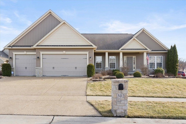 craftsman house with a garage, board and batten siding, concrete driveway, and a front yard