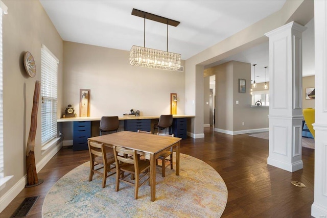 dining room featuring dark wood-style floors, visible vents, plenty of natural light, and ornate columns