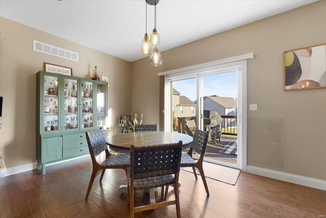 dining space featuring visible vents, baseboards, and wood finished floors