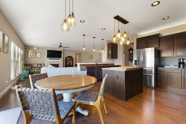 dining space with dark wood-type flooring, recessed lighting, a stone fireplace, baseboards, and ceiling fan