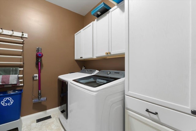 clothes washing area featuring visible vents, cabinet space, tile patterned flooring, baseboards, and washing machine and clothes dryer