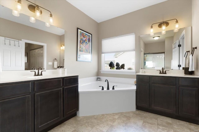 bathroom with a garden tub, two vanities, and a sink