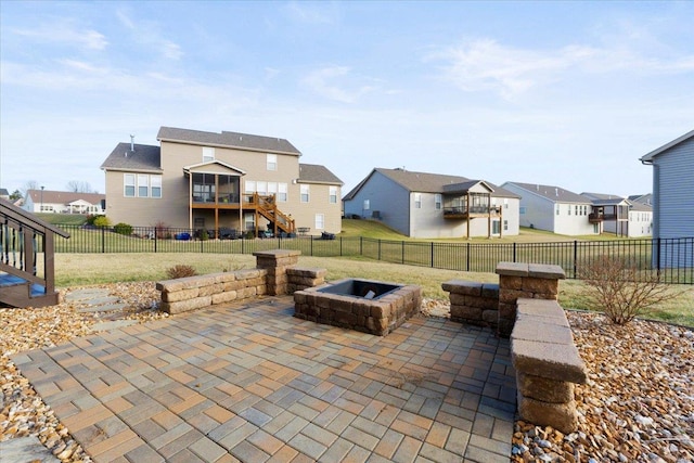 view of patio with stairway, a fire pit, a residential view, and a fenced backyard