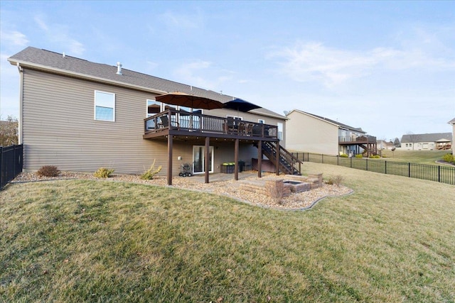 rear view of property featuring a wooden deck, a yard, a fenced backyard, and stairway