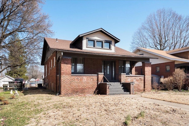 bungalow-style house with brick siding and covered porch