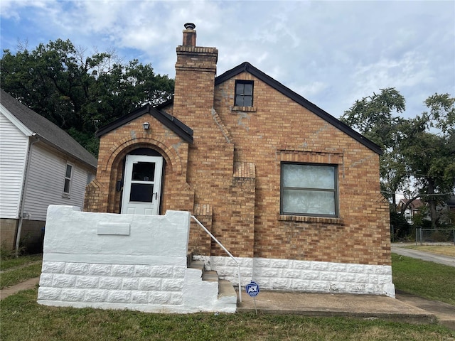 view of front of home with brick siding and a chimney