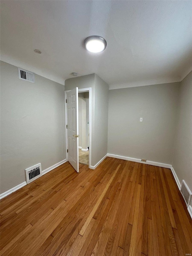 empty room with visible vents, baseboards, and light wood-style floors