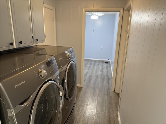 laundry room featuring wood finished floors, cabinet space, separate washer and dryer, baseboards, and ceiling fan