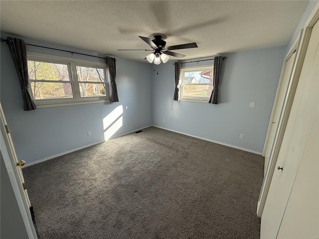 unfurnished bedroom featuring a ceiling fan, baseboards, visible vents, carpet floors, and a textured ceiling